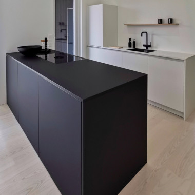 Tässä keittiössä yhdistetty rohkeasti täysin musta saareke muuten valkoisiin kalusteisiin.